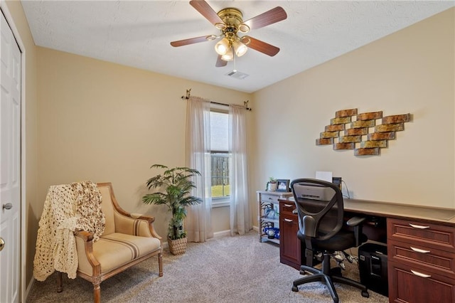 carpeted office with visible vents, baseboards, and ceiling fan