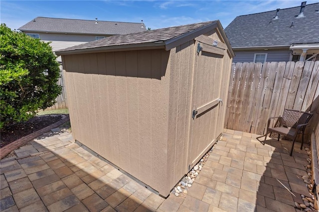 view of shed featuring fence