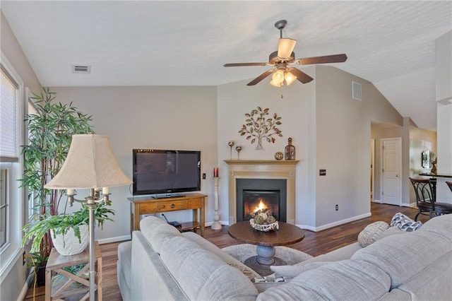 living area featuring visible vents, wood finished floors, ceiling fan, and lofted ceiling