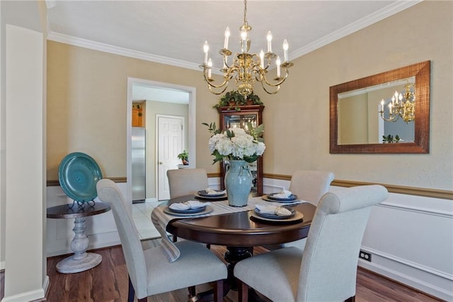 dining space featuring ornamental molding, wood finished floors, and a chandelier