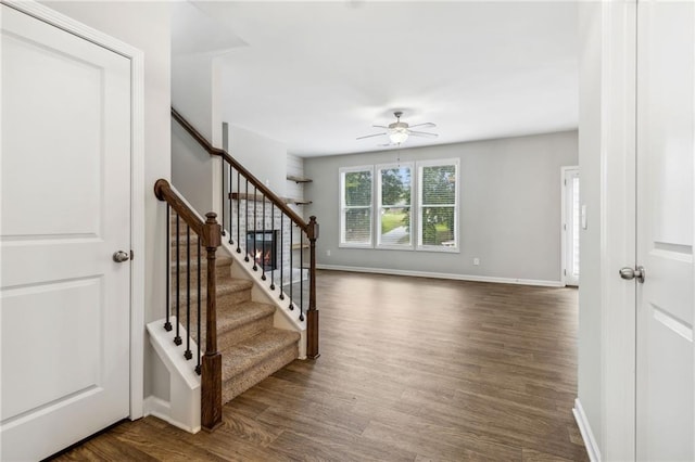 stairs with hardwood / wood-style flooring and ceiling fan