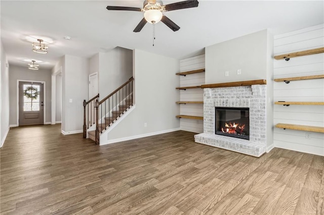 unfurnished living room featuring hardwood / wood-style flooring, ceiling fan, and a fireplace