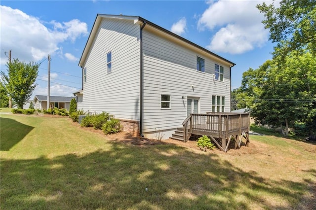 rear view of property featuring a lawn and a deck