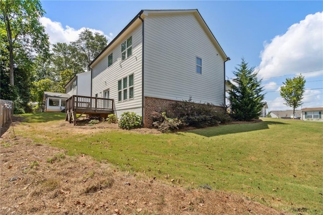 view of side of home featuring a wooden deck and a yard