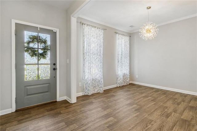 foyer entrance with ornamental molding, wood-type flooring, and an inviting chandelier