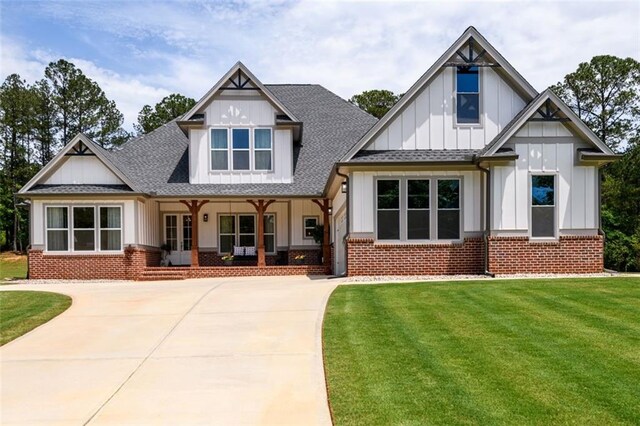 400 Fox Valley Dr, Monroe, GA 30656 - back of house featuring board and batten siding, a porch, brick siding, a lawn, and a shingled roof