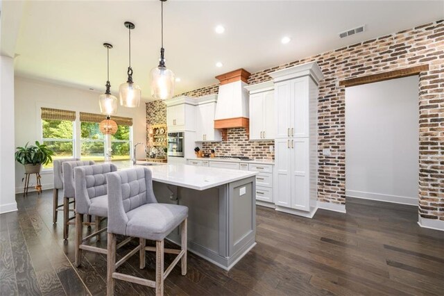 400 Fox Valley Dr, Monroe, GA 30656 - kitchen with oven, a sink, light countertops, dark wood-style floors, and a center island with sink