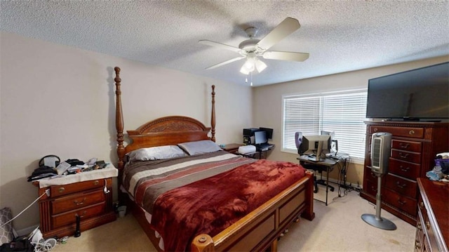 bedroom with ceiling fan, light colored carpet, and a textured ceiling