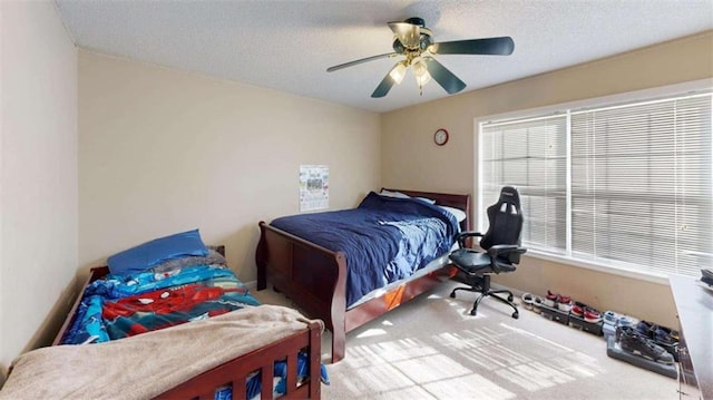 carpeted bedroom featuring a textured ceiling and ceiling fan