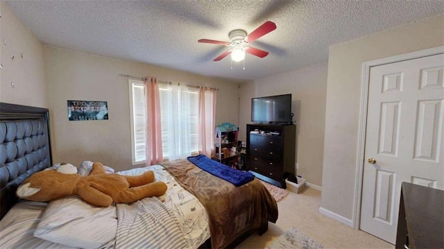 carpeted bedroom featuring ceiling fan and a textured ceiling