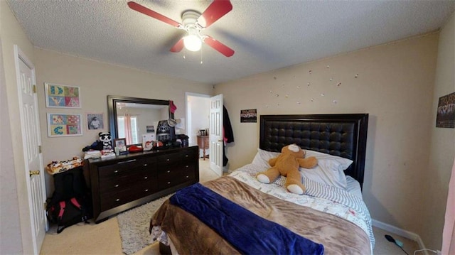 carpeted bedroom with ceiling fan and a textured ceiling