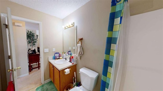 bathroom featuring vanity, curtained shower, toilet, and a textured ceiling