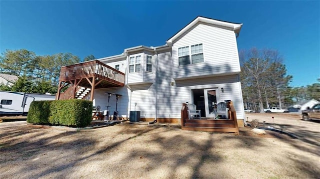 rear view of property featuring a wooden deck and central AC