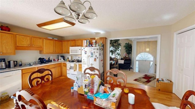 dining area with sink, a textured ceiling, and light wood-type flooring