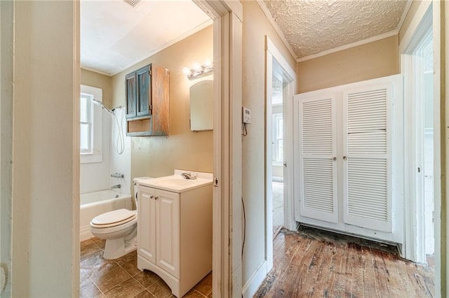 bathroom featuring vanity, ornamental molding, bathing tub / shower combination, and toilet