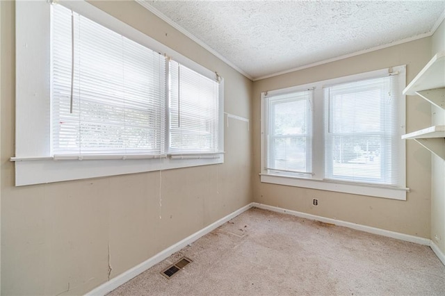 unfurnished room featuring carpet floors, ornamental molding, baseboards, and visible vents