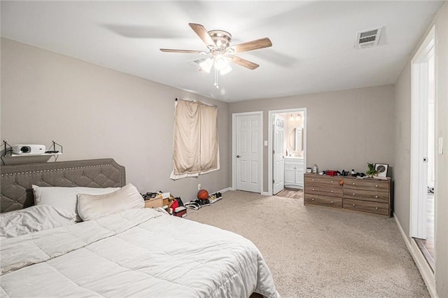 carpeted bedroom with baseboards, ceiling fan, ensuite bath, and visible vents