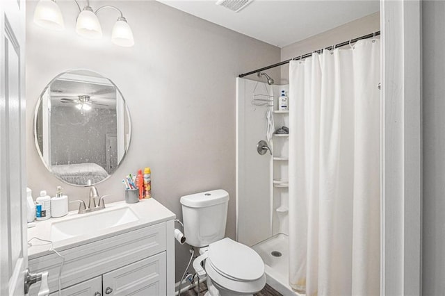 bathroom with toilet, visible vents, ceiling fan, a shower stall, and vanity