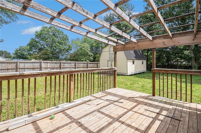 wooden terrace featuring a fenced backyard, a storage shed, and an outbuilding