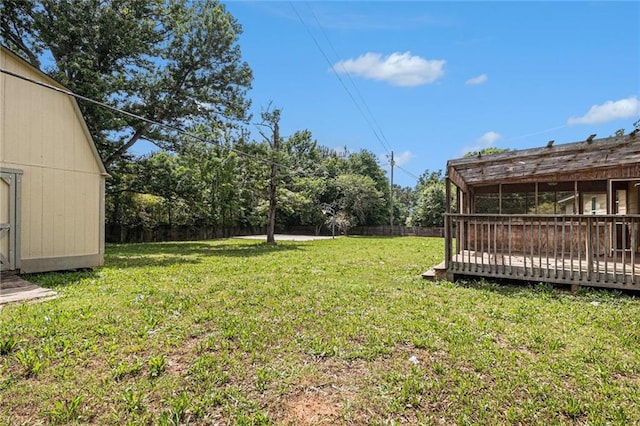view of yard with a deck, a shed, and an outbuilding