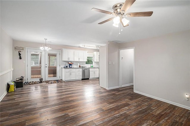 unfurnished living room with baseboards, ceiling fan with notable chandelier, a sink, and dark wood-style floors