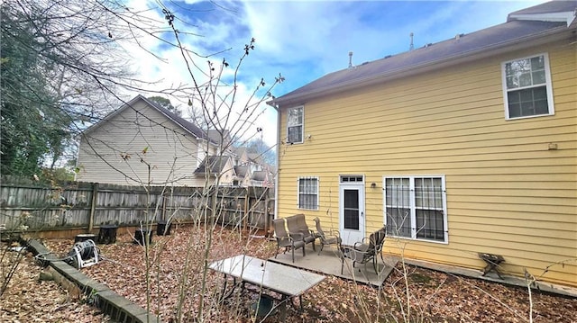 back of property featuring a patio area and fence