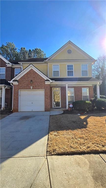 traditional home featuring brick siding, an attached garage, and concrete driveway