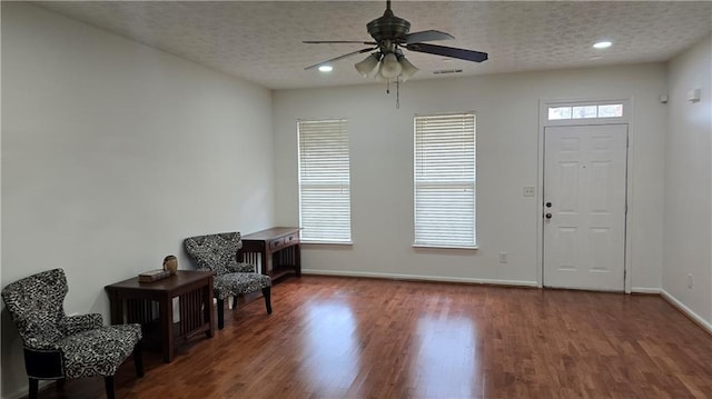 foyer entrance with plenty of natural light, a textured ceiling, and wood finished floors