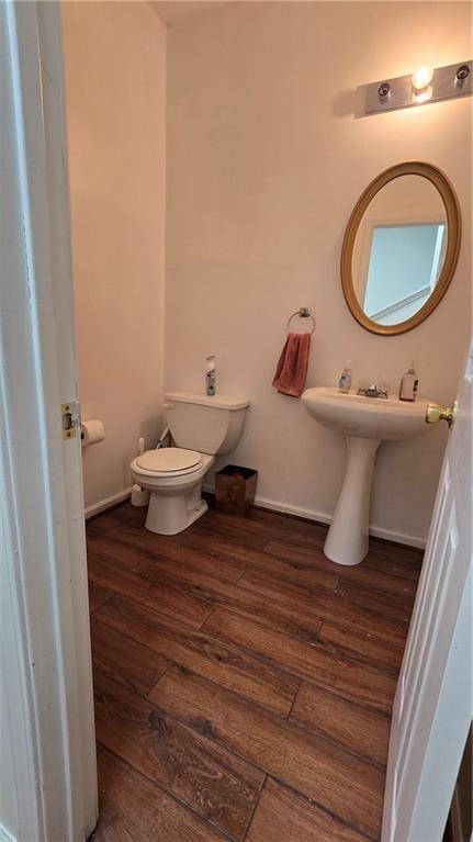 bathroom featuring toilet, baseboards, and wood finished floors