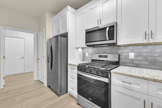 1249 Creek Forest Ln Bldg 8, Austell, GA 30106 - kitchen with stainless steel appliances, light wood-style flooring, white cabinetry, backsplash, and light stone counters