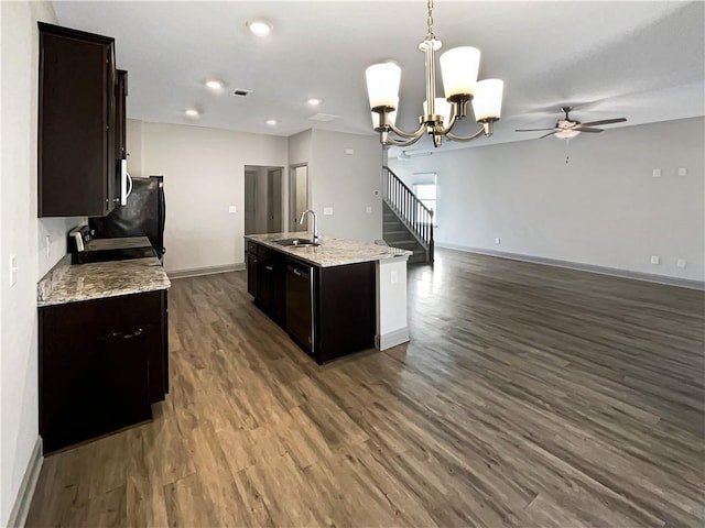 kitchen featuring baseboards, a kitchen island with sink, a sink, dark wood-type flooring, and range