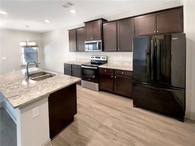 kitchen featuring baseboards, a kitchen island with sink, a sink, dark wood-type flooring, and range