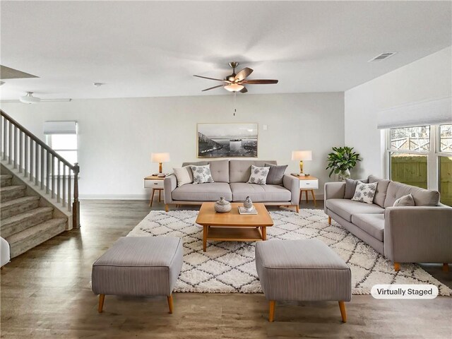 empty room featuring stairs, wood finished floors, visible vents, and baseboards