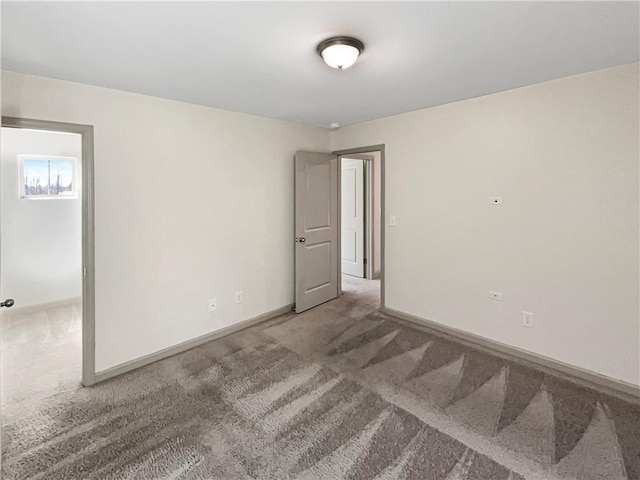 unfurnished room with baseboards and carpet flooring