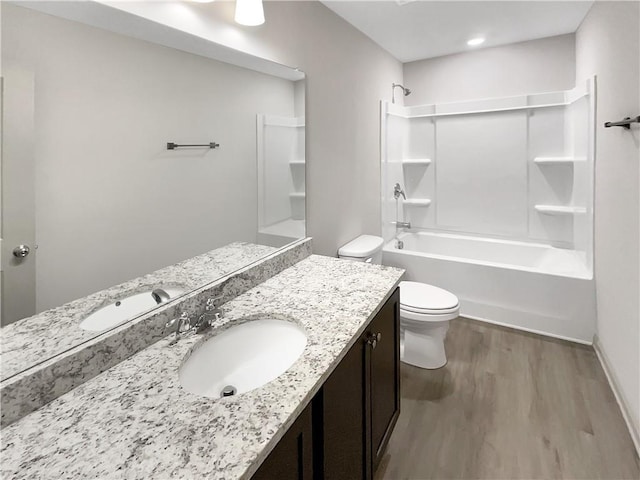 bathroom with vanity, shower / bathing tub combination, toilet, and wood finished floors