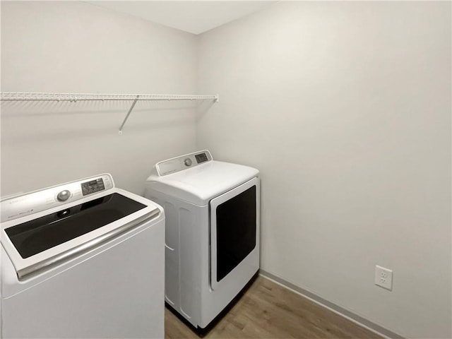 washroom featuring light wood-type flooring, washing machine and dryer, and laundry area