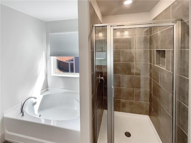 full bath with a shower stall and a garden tub