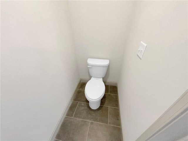 bathroom featuring tile patterned flooring, toilet, and baseboards