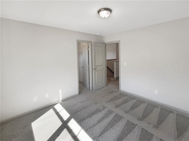 carpeted empty room featuring baseboards