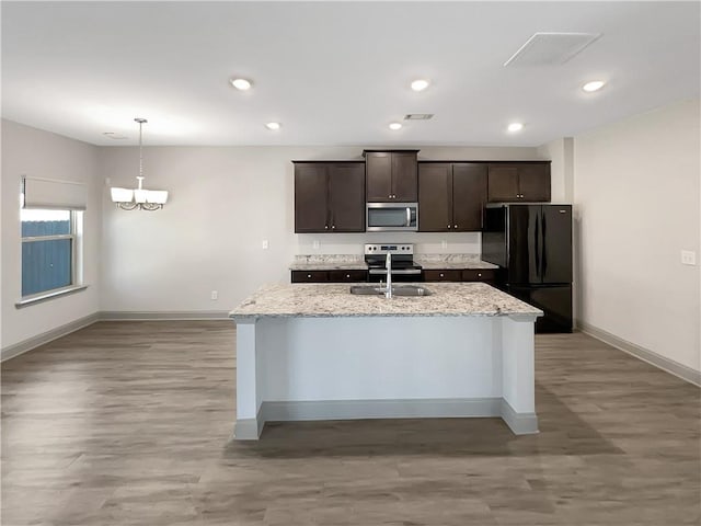 kitchen with baseboards, stainless steel appliances, light stone countertops, and dark brown cabinets