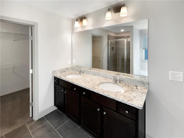 full bath featuring a shower stall, double vanity, tile patterned floors, and a sink