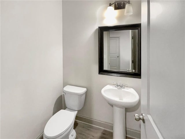 bathroom featuring baseboards and toilet