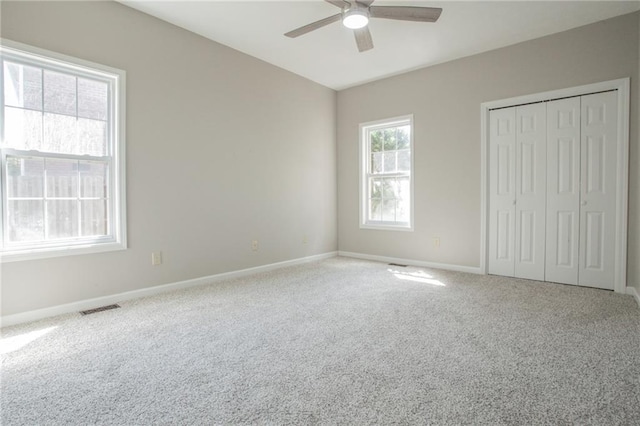 unfurnished bedroom with ceiling fan, a closet, and carpet floors