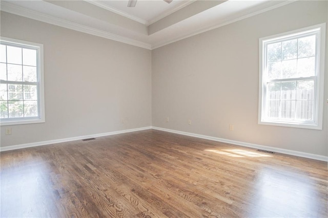 spare room with wood-type flooring, a wealth of natural light, crown molding, and ceiling fan