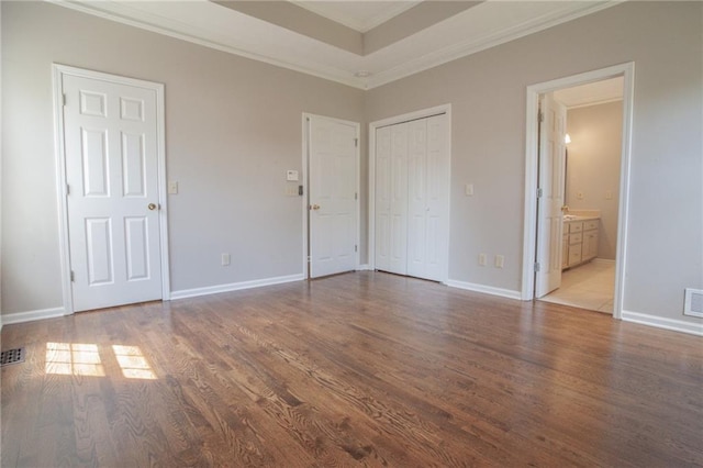 unfurnished bedroom with ornamental molding, hardwood / wood-style floors, and ensuite bathroom