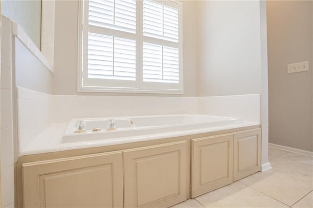 bathroom with a bath and tile patterned flooring