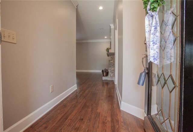 corridor featuring dark wood-type flooring and ornamental molding