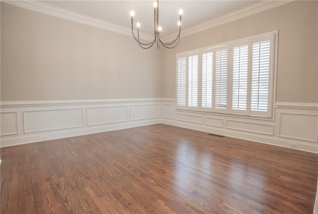 unfurnished room with wood-type flooring, an inviting chandelier, and ornamental molding