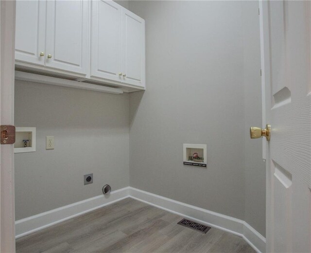 clothes washing area featuring light wood-type flooring, hookup for a washing machine, cabinets, and electric dryer hookup