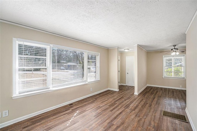 empty room with dark wood-type flooring, a textured ceiling, ceiling fan, and crown molding